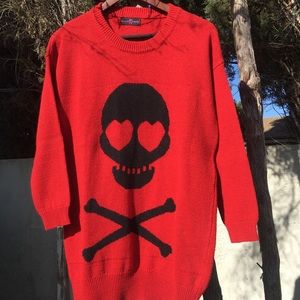 Red sweater with black skull on it .